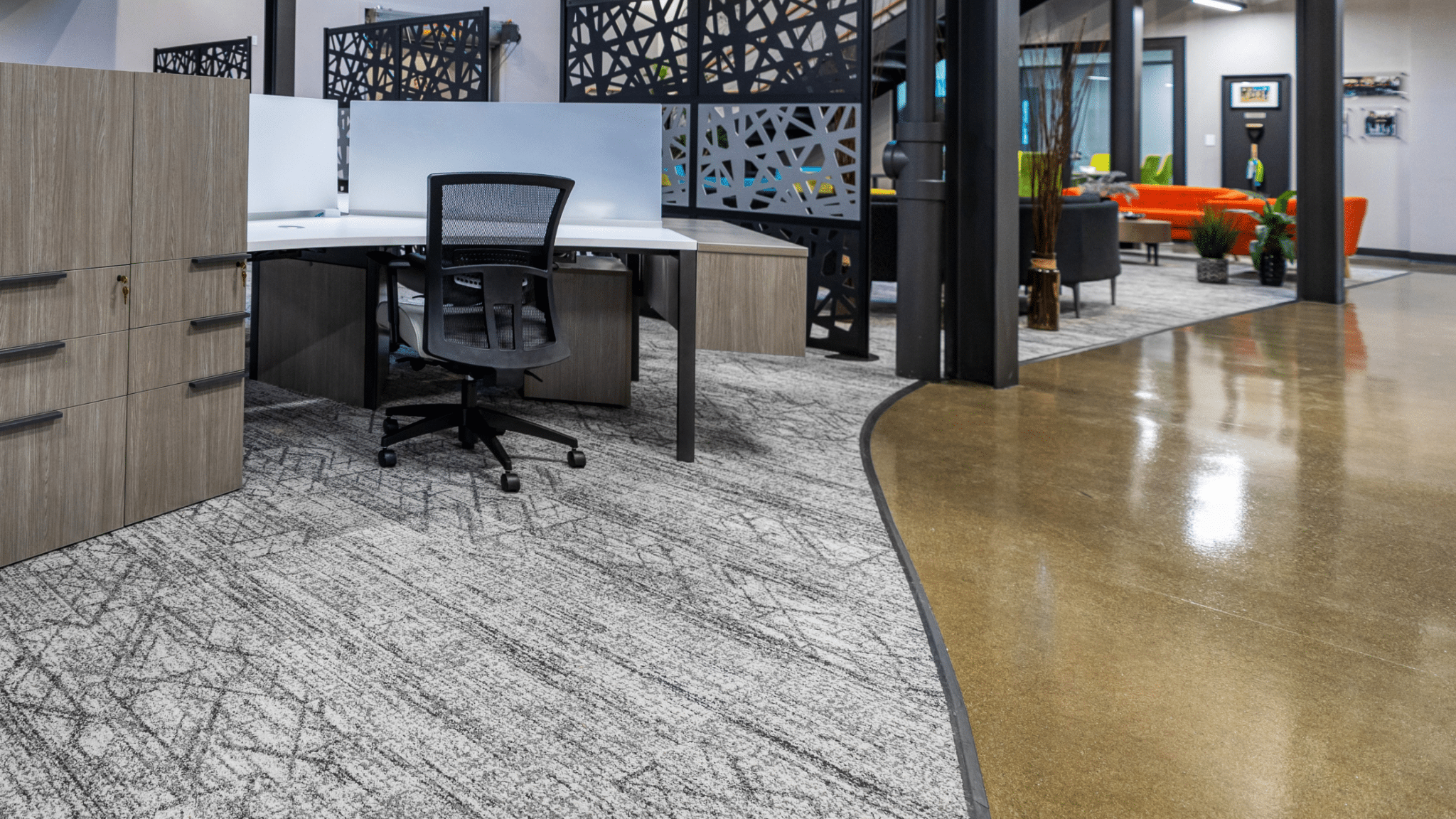 A contemporary interior space shows two types of office flooring near cubicles.