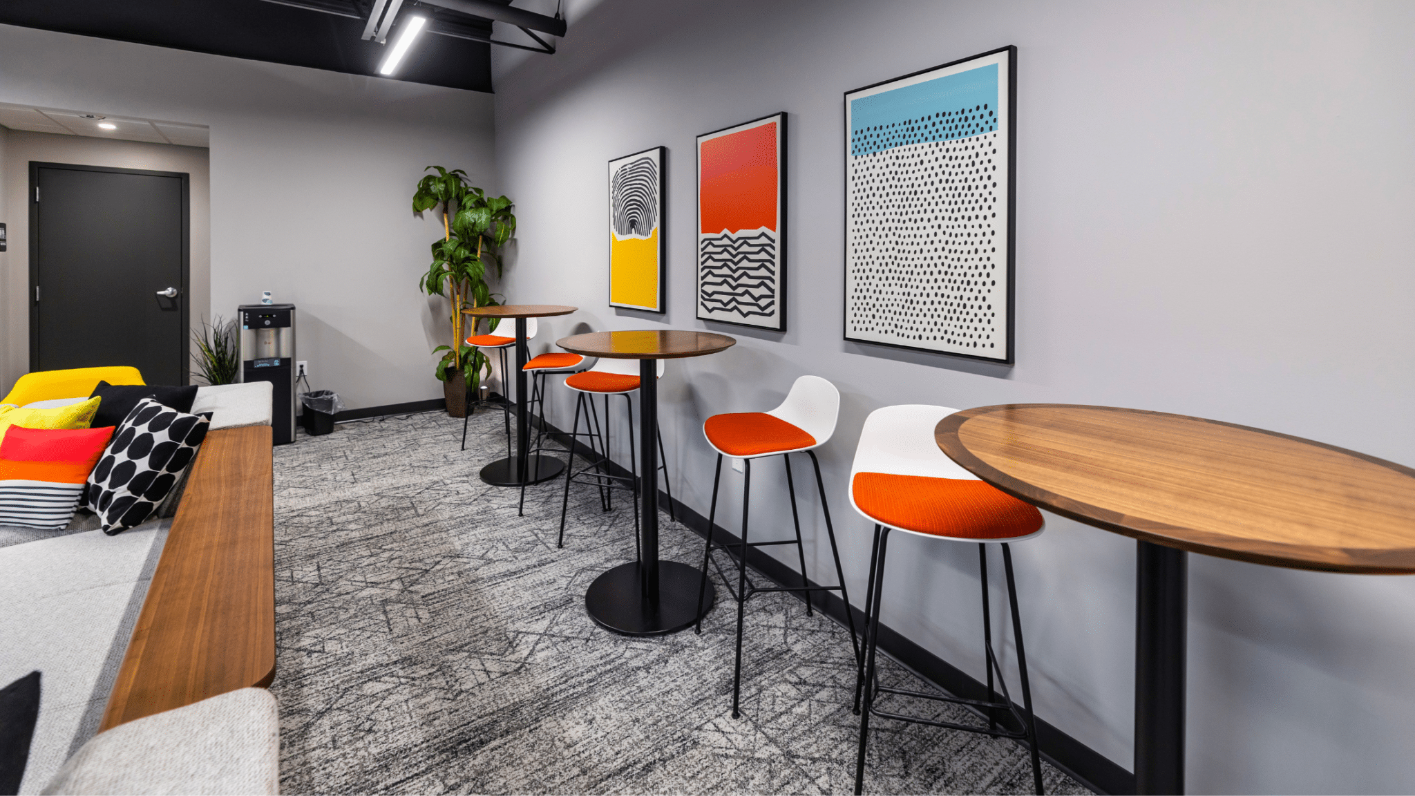 The interior of a commercial space featuring bright, colored art and wood tones to depict interior design trends of 2023.
