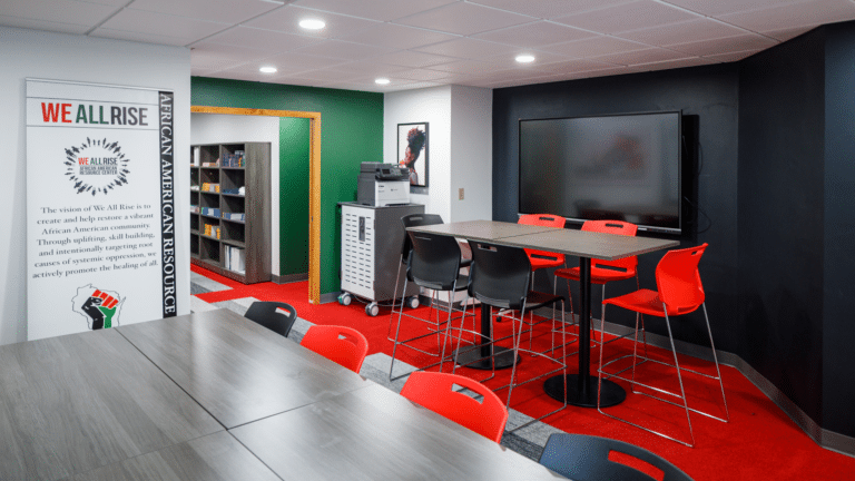 The interior of the We All Rise resource center featuring red, green, and black design elements.