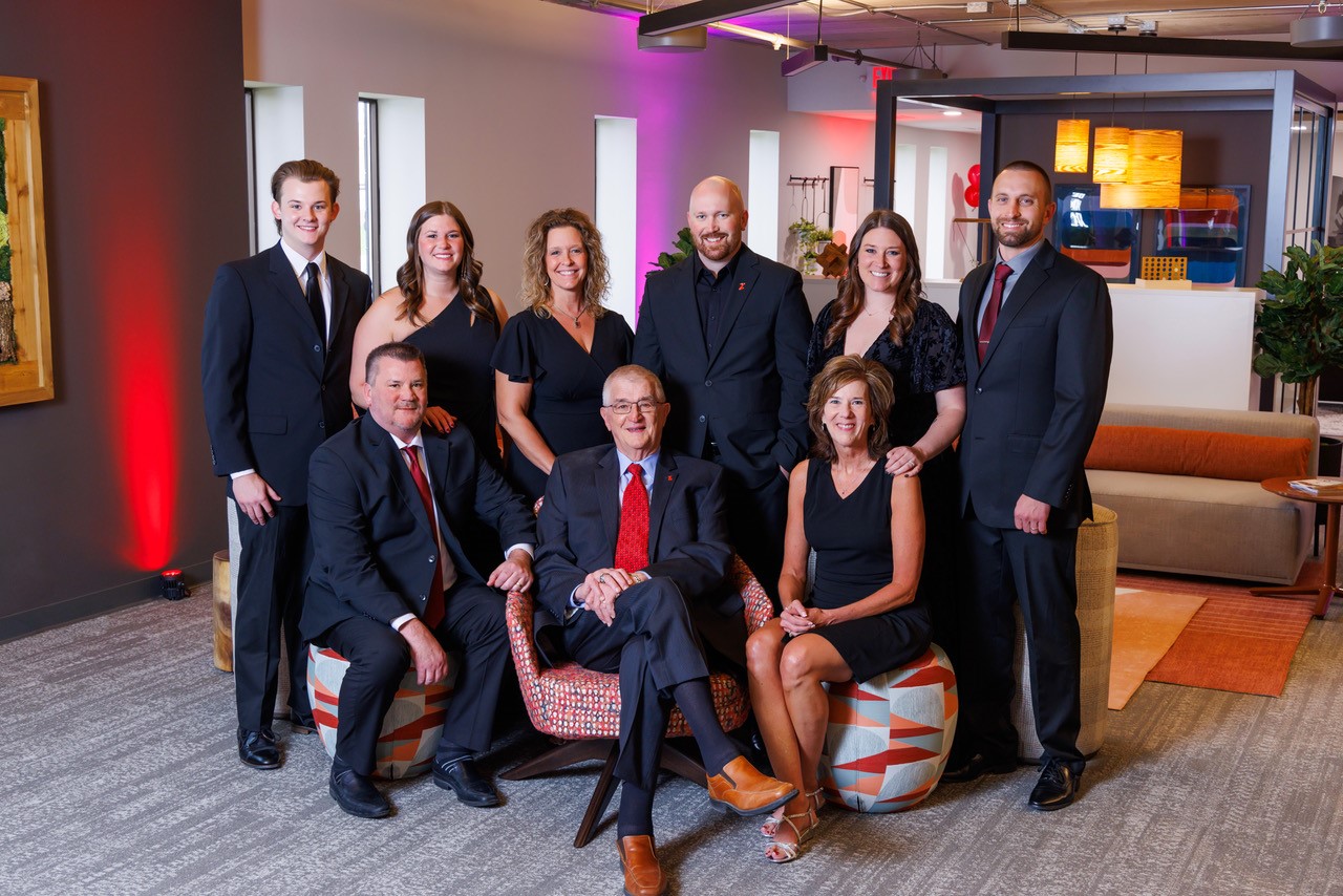 Three generations of the CJ & Associates family standing together, representing the enduring legacy and team spirit behind our commercial interiors company.